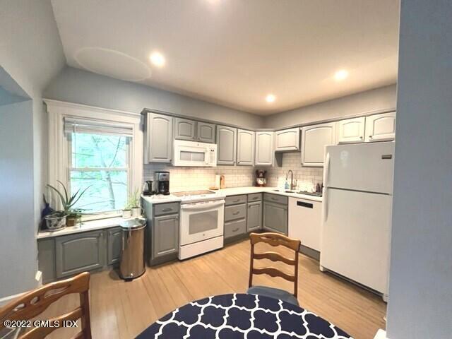 32 Ridge Street, Unit 2 Greenwich, CT 06830 - Photo 2 of 19 a kitchen with a refrigerator a sink dishwasher a stove and white cabinets with wooden floor