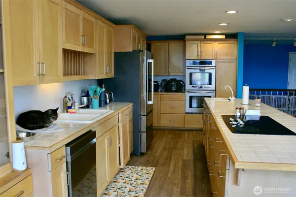 a kitchen with stainless steel appliances a stove a sink a refrigerator and cabinets