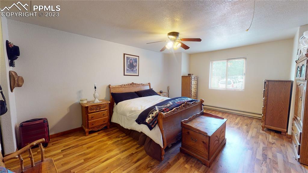 1011 Castle Ridge View Cripple Creek, CO 80813 - Photo 21 of 48 a bedroom with a bed wooden floor and window