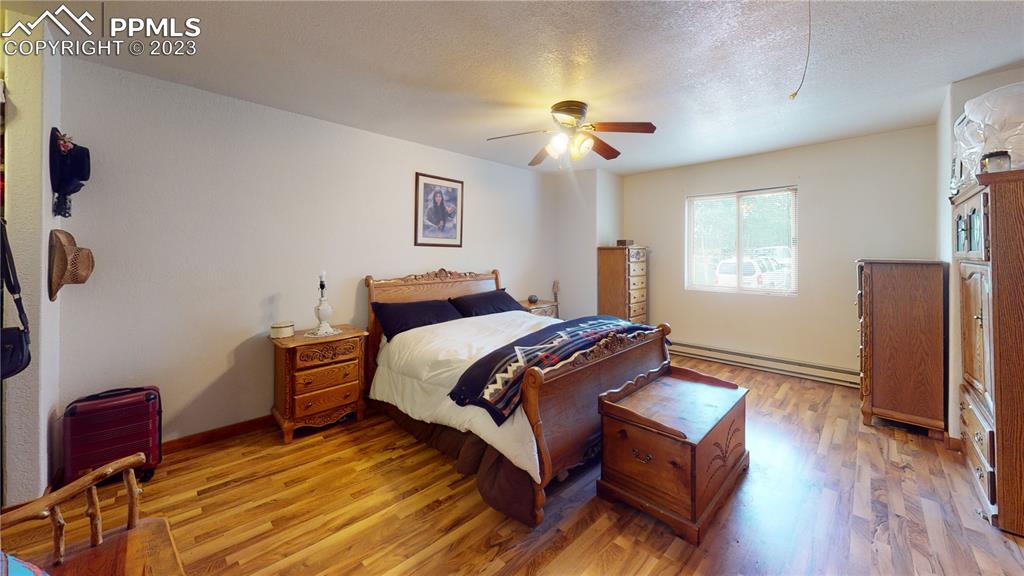 1011 Castle Ridge View Cripple Creek, CO 80813 - Photo 31 of 48 a bedroom with a bed and wooden floor