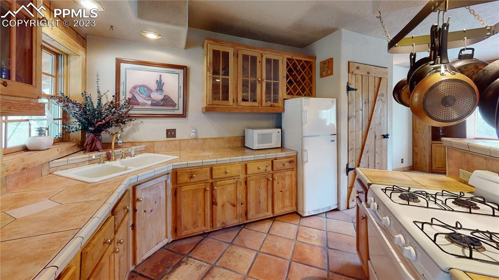 1011 Castle Ridge View Cripple Creek, CO 80813 - Photo 41 of 48 a kitchen with a sink stove and cabinets