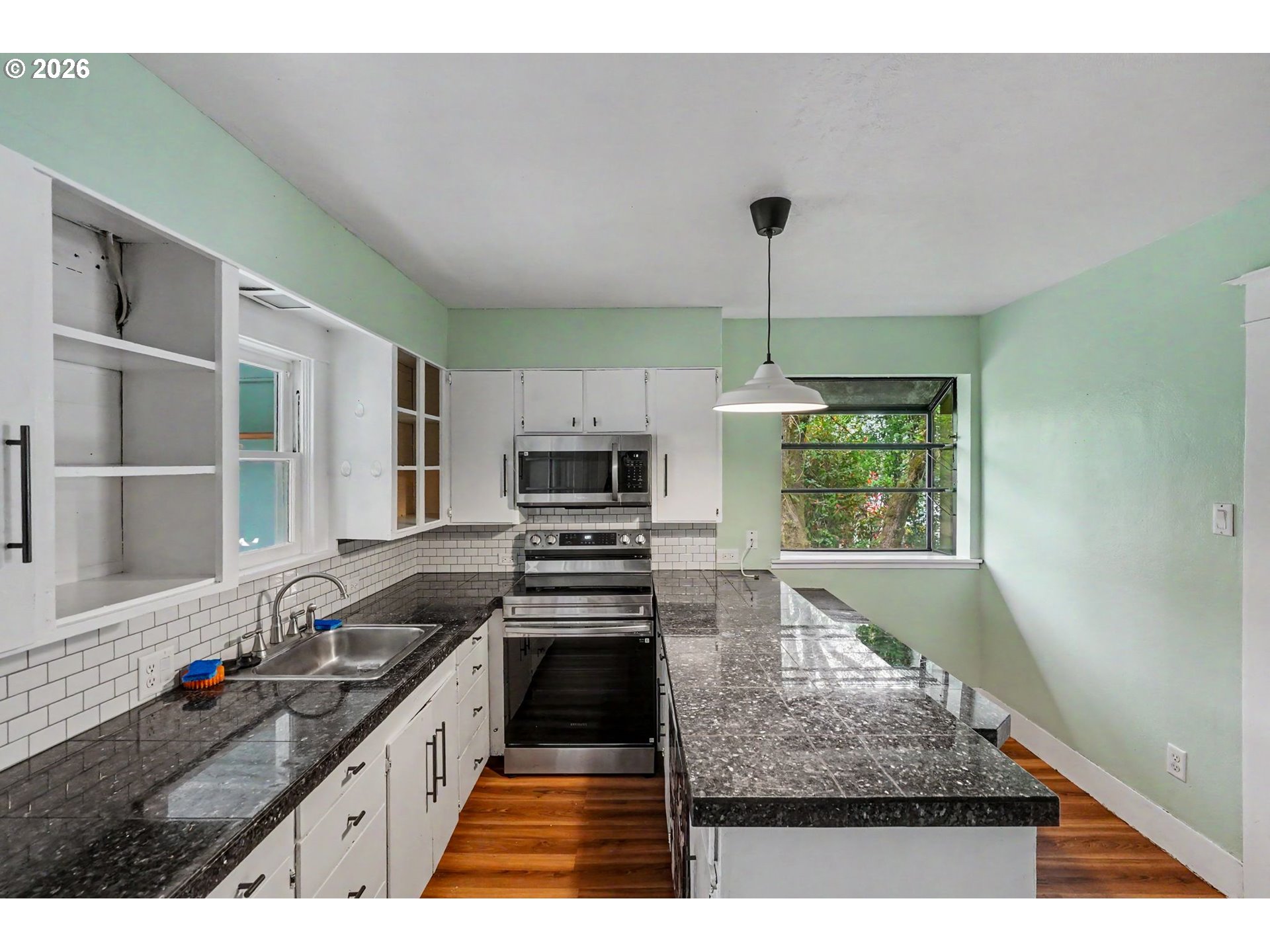 301 Orchard Street Silverton, OR 97381 - Photo 17 of 42 a kitchen with stainless steel appliances a stove sink and microwave