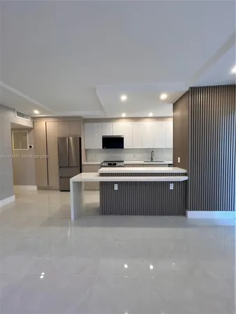 a kitchen with stainless steel appliances kitchen island granite countertop a stove a sink and a refrigerator