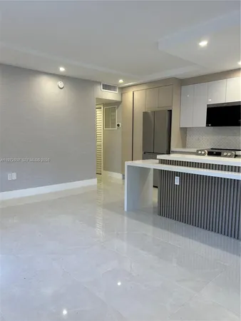a view of a kitchen with a sink wooden cabinets and stainless steel appliances
