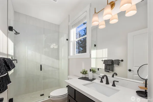 a bathroom with a sink a toilet and shower