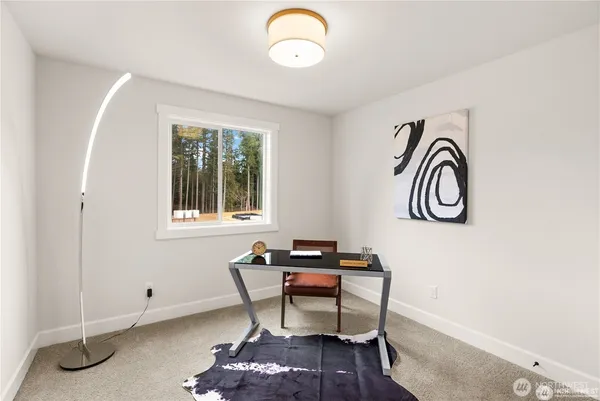 a view of a workspace room with furniture and window