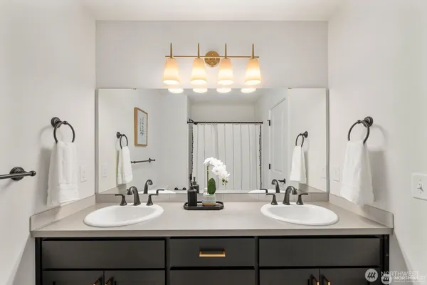 a bathroom with double vanity sinks and a mirror