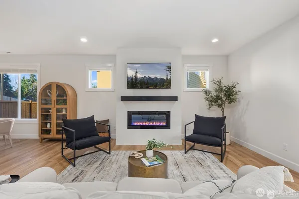 a living room with furniture a fireplace and a floor to ceiling window