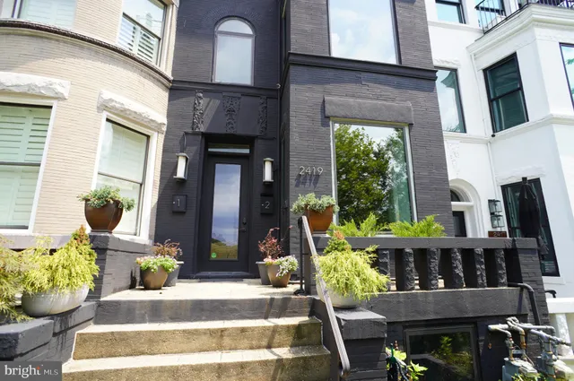 a front view of a house with outdoor seating and plants