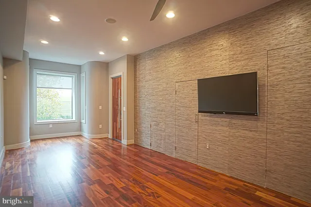 a view of a livingroom with wooden floor and staircase