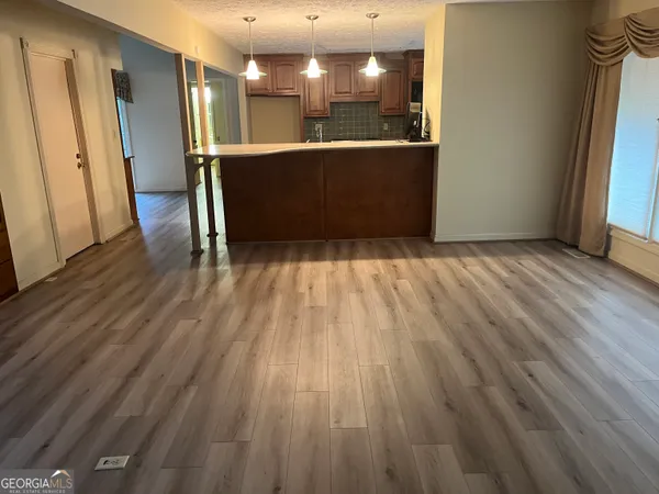 a view of kitchen with wooden floor and electronic appliances