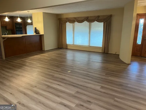 a view of a room with wooden floor and furniture