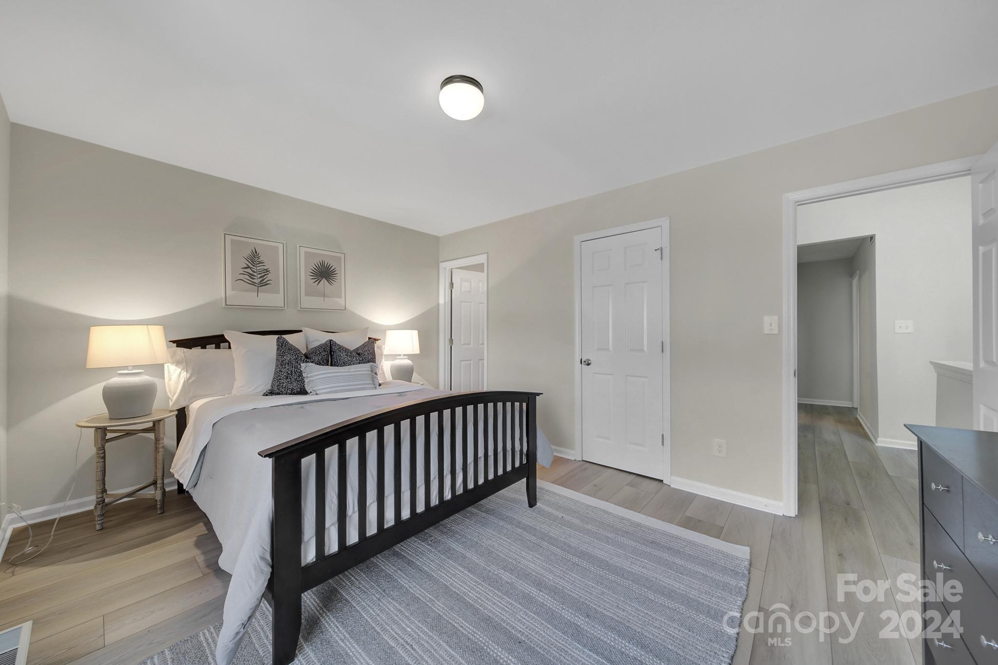 10943 Carmel Crossing Road Charlotte, NC 28226 - Photo 14 of 28 a view of a bedroom with furniture and wooden floor