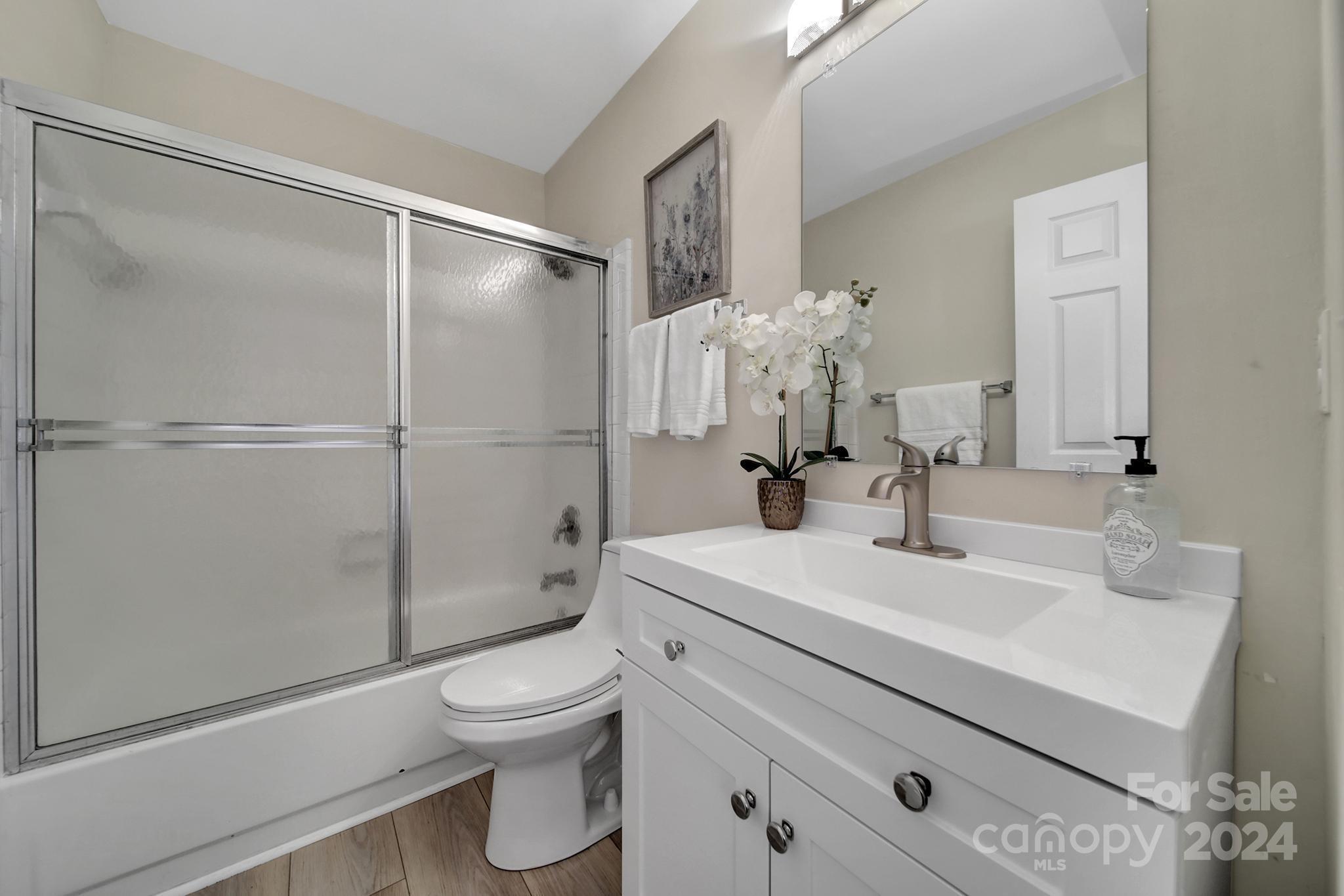 10943 Carmel Crossing Road Charlotte, NC 28226 - Photo 16 of 28 a bathroom with a sink a toilet and shower