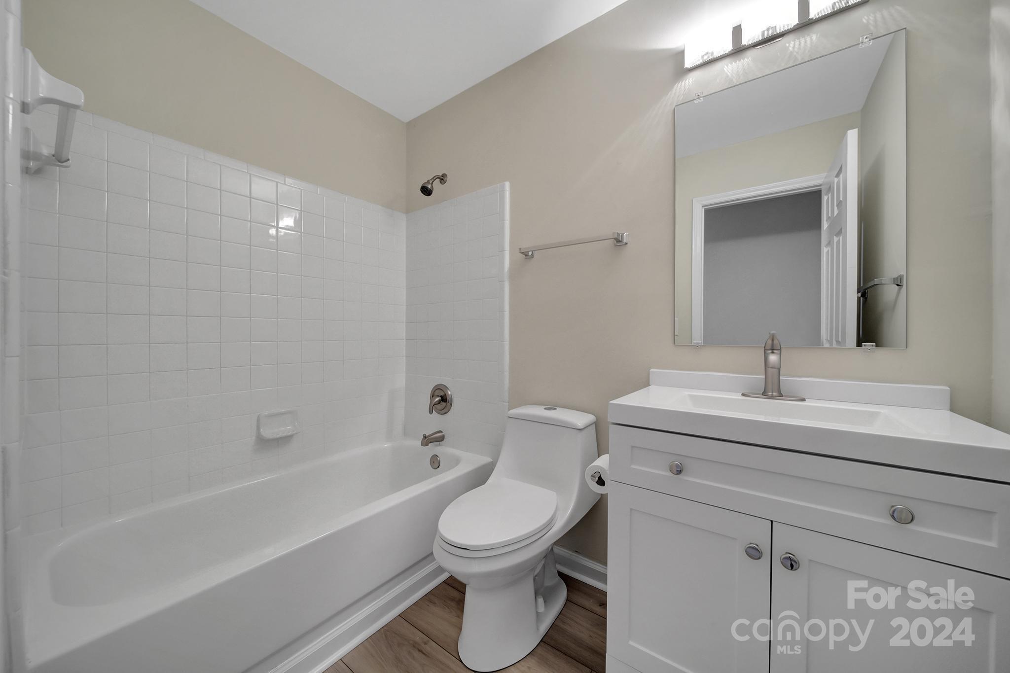 10943 Carmel Crossing Road Charlotte, NC 28226 - Photo 18 of 28 a bathroom with a toilet a sink and a bathtub