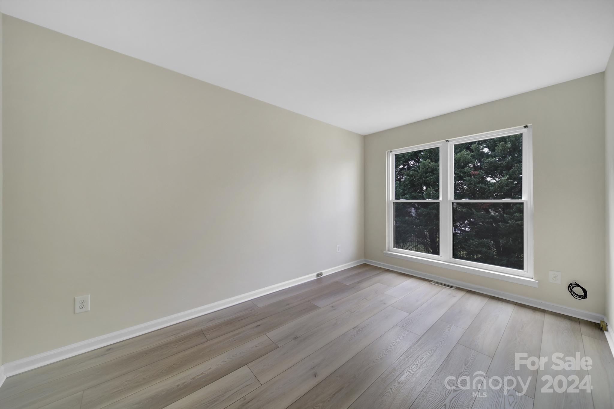 10943 Carmel Crossing Road Charlotte, NC 28226 - Photo 19 of 28 wooden floor and window in an empty room