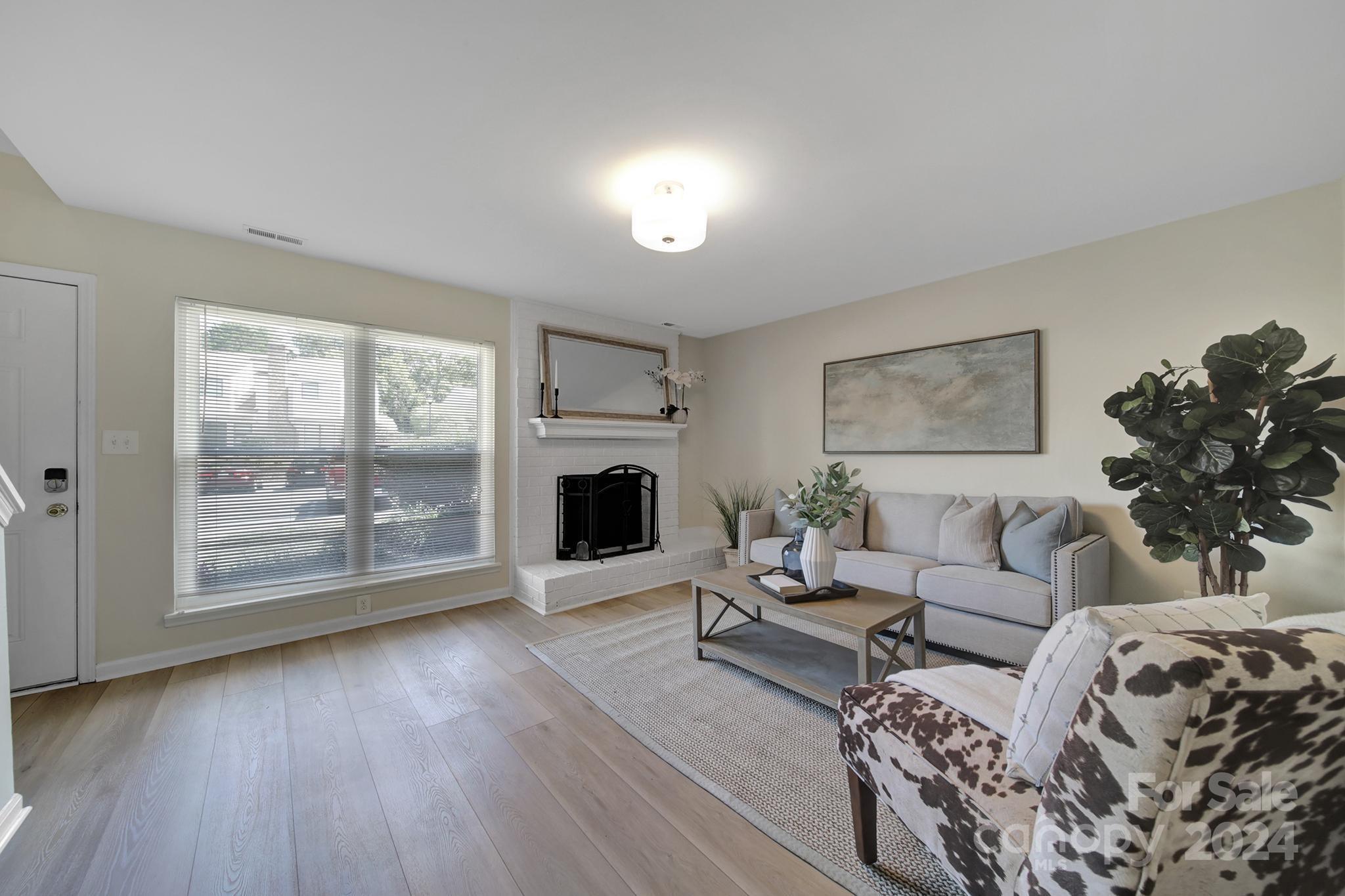 10943 Carmel Crossing Road Charlotte, NC 28226 - Photo 2 of 28 a living room with furniture a large window and a fireplace