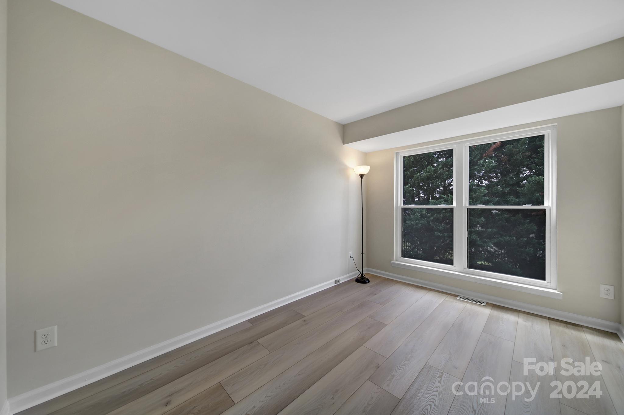 10943 Carmel Crossing Road Charlotte, NC 28226 - Photo 21 of 28 an empty room with wooden floor and windows