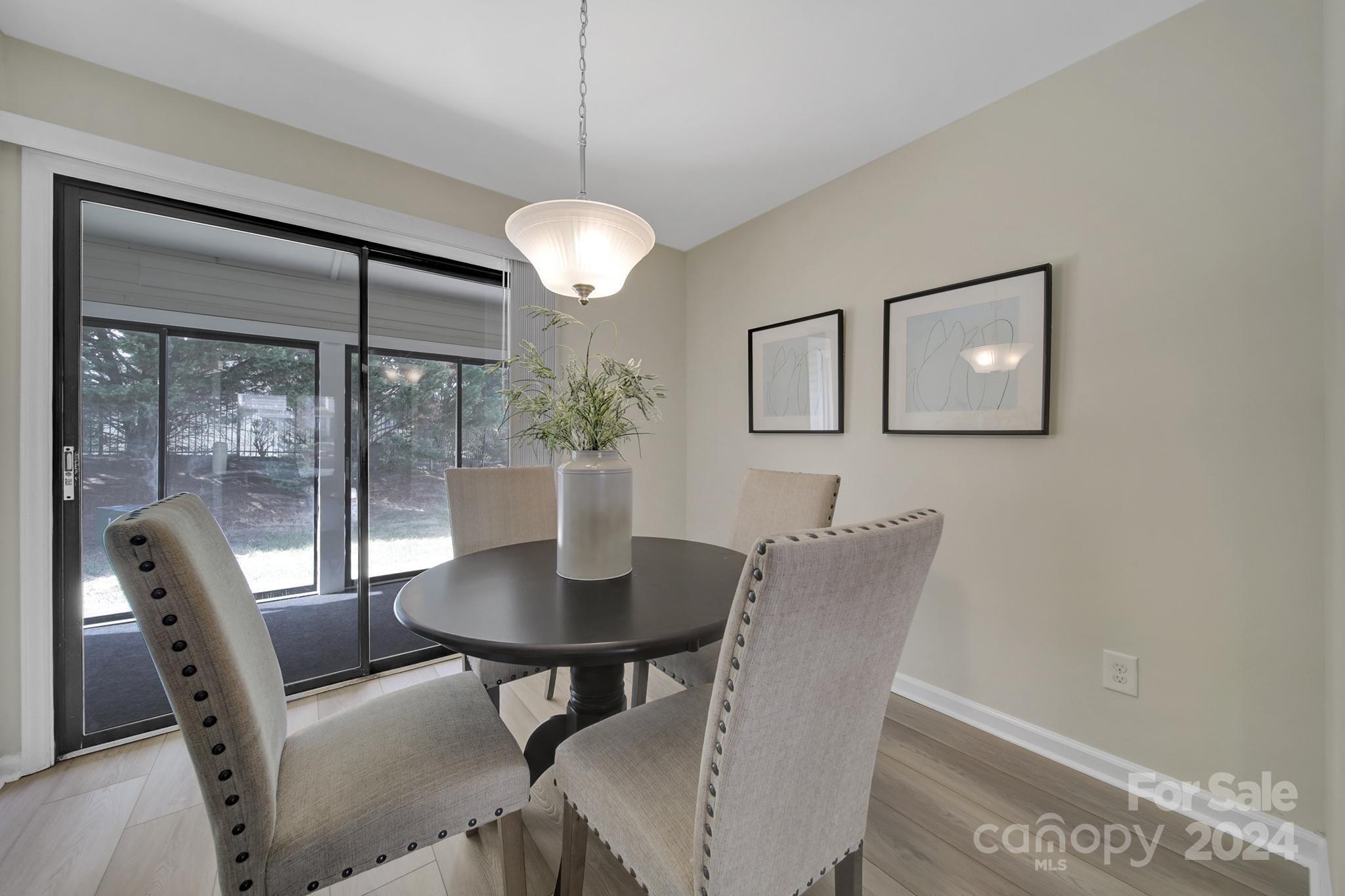 10943 Carmel Crossing Road Charlotte, NC 28226 - Photo 5 of 28 a view of a dining room with furniture wooden floor and chandelier