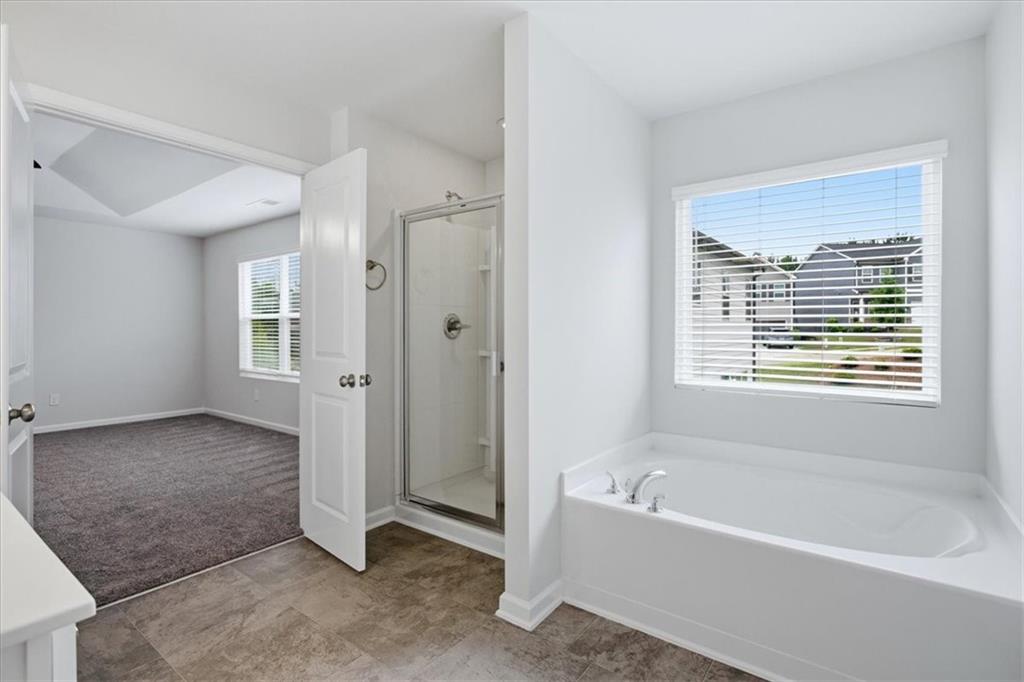 585 Summit Point Canton, GA 30114 - Photo 16 of 30 a bathroom with a bathtub and a shower