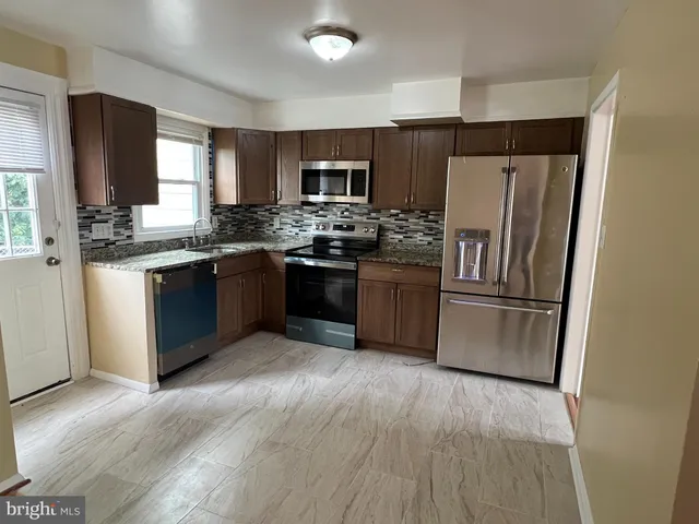 a kitchen with stainless steel appliances granite countertop a refrigerator stove and sink