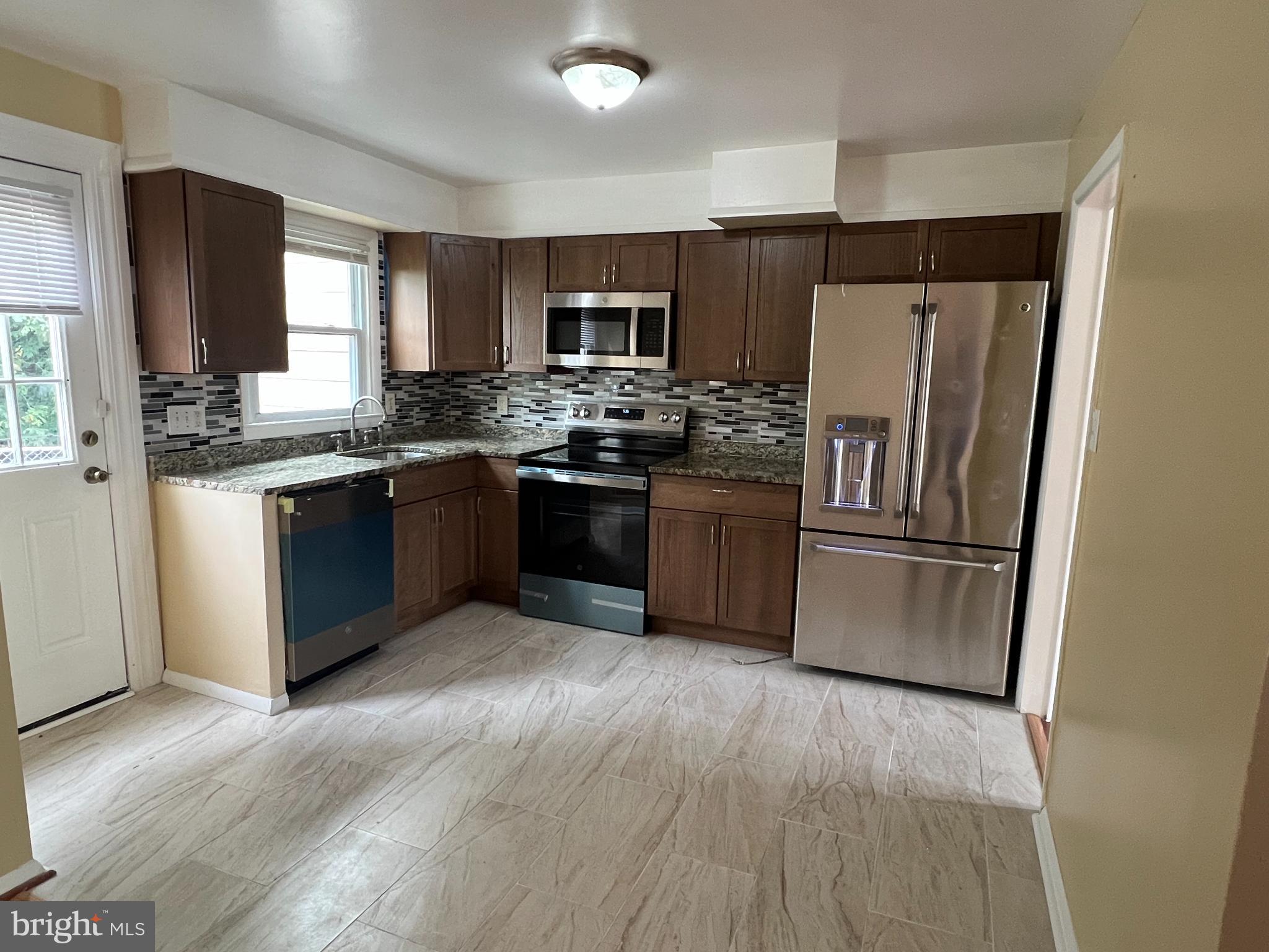 8503 Stevenswood Road Windsor Mill, MD 21244 - Photo 10 of 18 a kitchen with stainless steel appliances granite countertop a refrigerator stove and sink