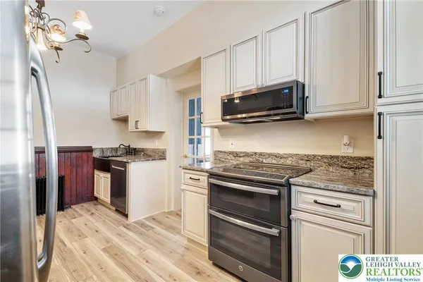 a kitchen with granite countertop a refrigerator stove and microwave
