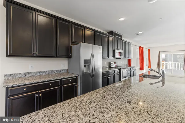 a kitchen with stainless steel appliances granite countertop a refrigerator stove top oven a sink and dishwasher