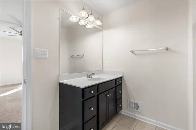 a bathroom with a sink a light fixture and a mirror