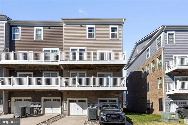 a front view of residential building with large windows and a yard