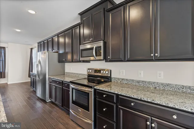 a kitchen with granite countertop stainless steel appliances and wooden cabinets