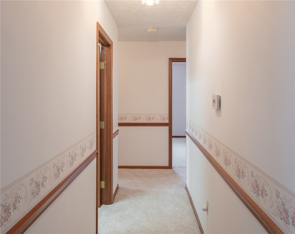 276 South Fairfield Road Bellbrook, OH 45305 - Photo 19 of 38 This interior hallway features classic wood trim and soft carpet, creating a warm, inviting atmosphere.