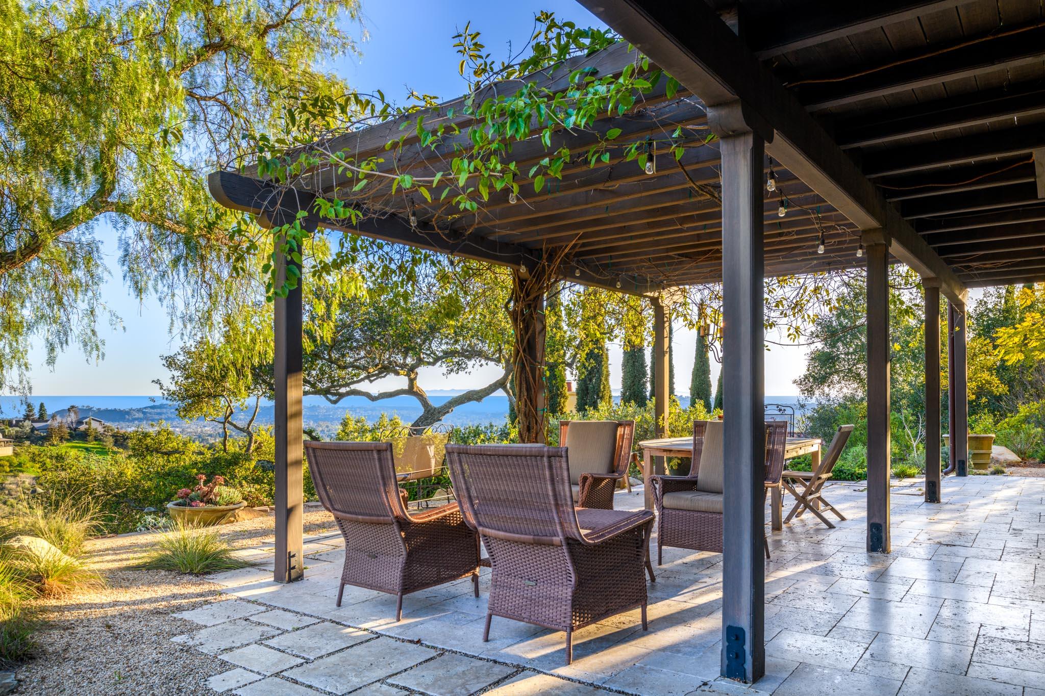 1250 Northridge Road Santa Barbara, CA 93105 - Photo 19 of 37 a view of a patio with table and chairs potted plants and large tree