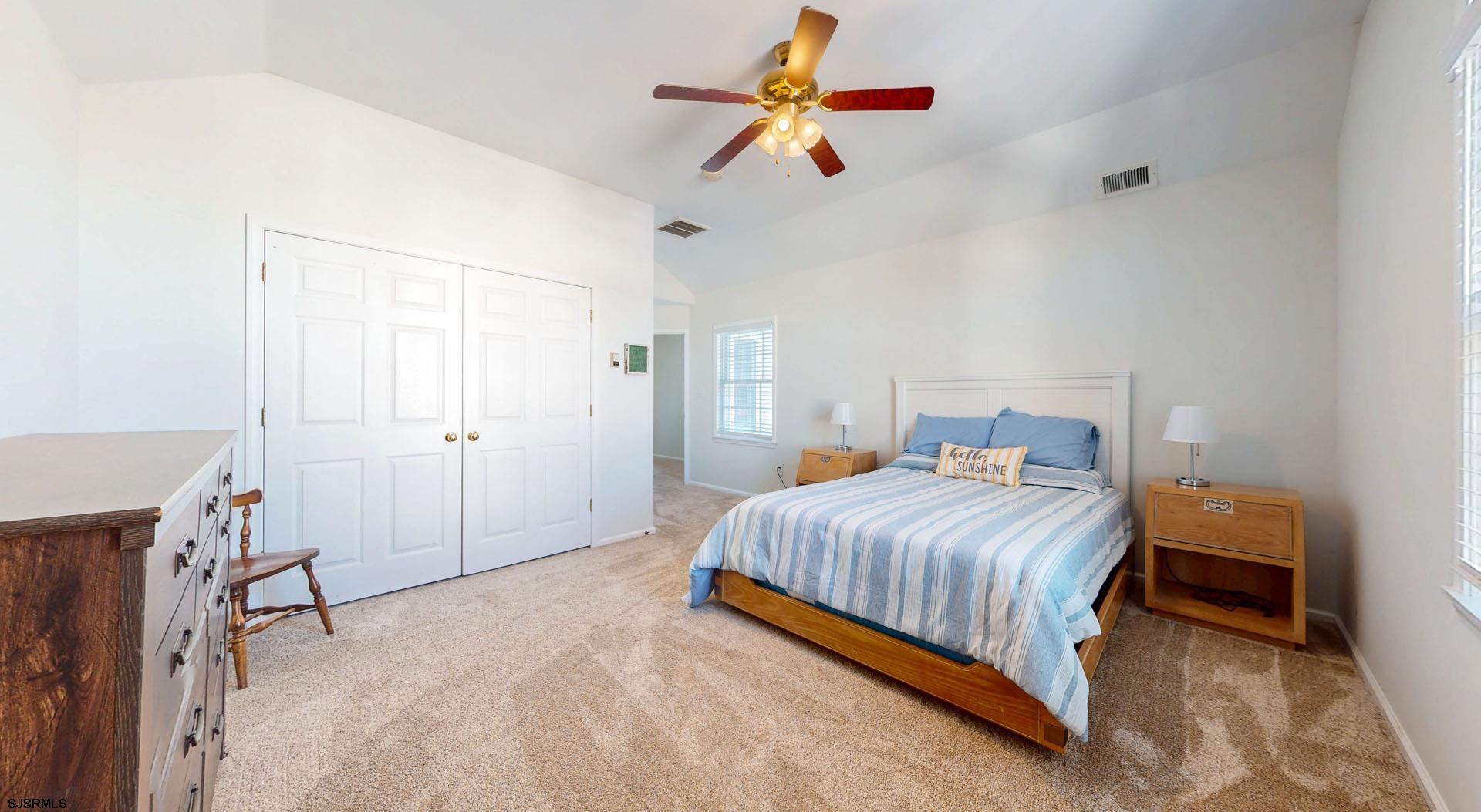 39 Spruce Road Ocean City, NJ 08226 - Photo 34 of 51 a bedroom with a bed and a chandelier