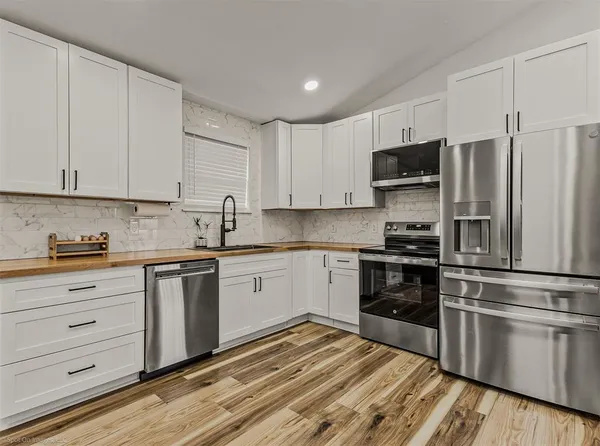 a kitchen with appliances a sink and cabinets