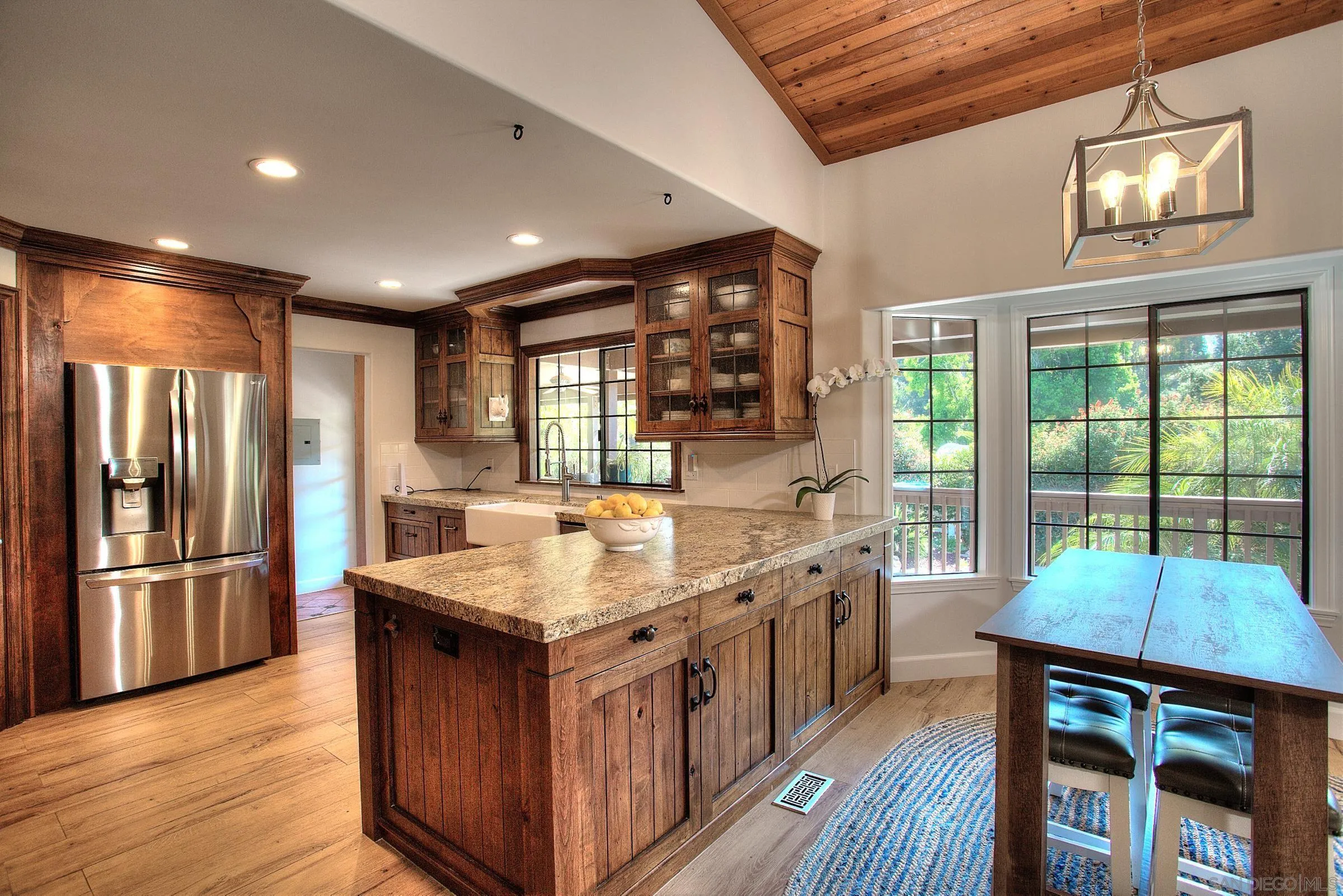 1032 Los Alisos Drive North Fallbrook, CA 92028 - Photo 12 of 44 a kitchen with kitchen island granite countertop a large center island and a wooden floor