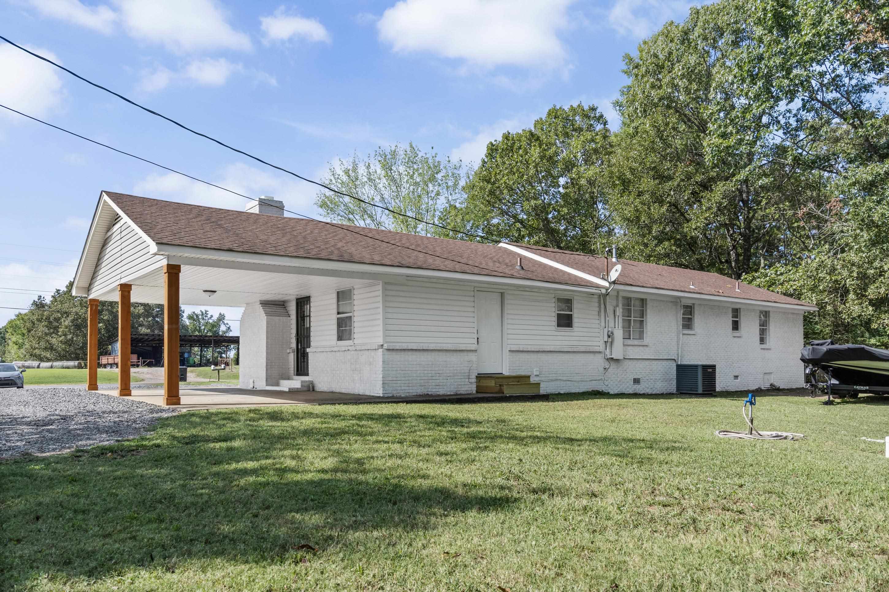 2805 Slayden Road Moscow, TN 38057 - Photo 14 of 28 Rear view of property with brick siding, a yard, a shingled roof, and an attached carport