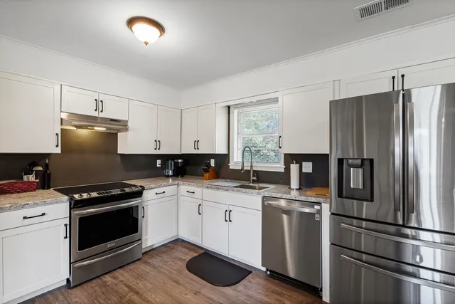a kitchen with white cabinets and stainless steel appliances