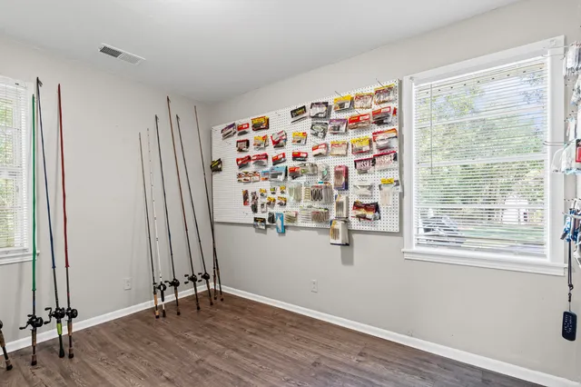an empty room with wooden floor and windows