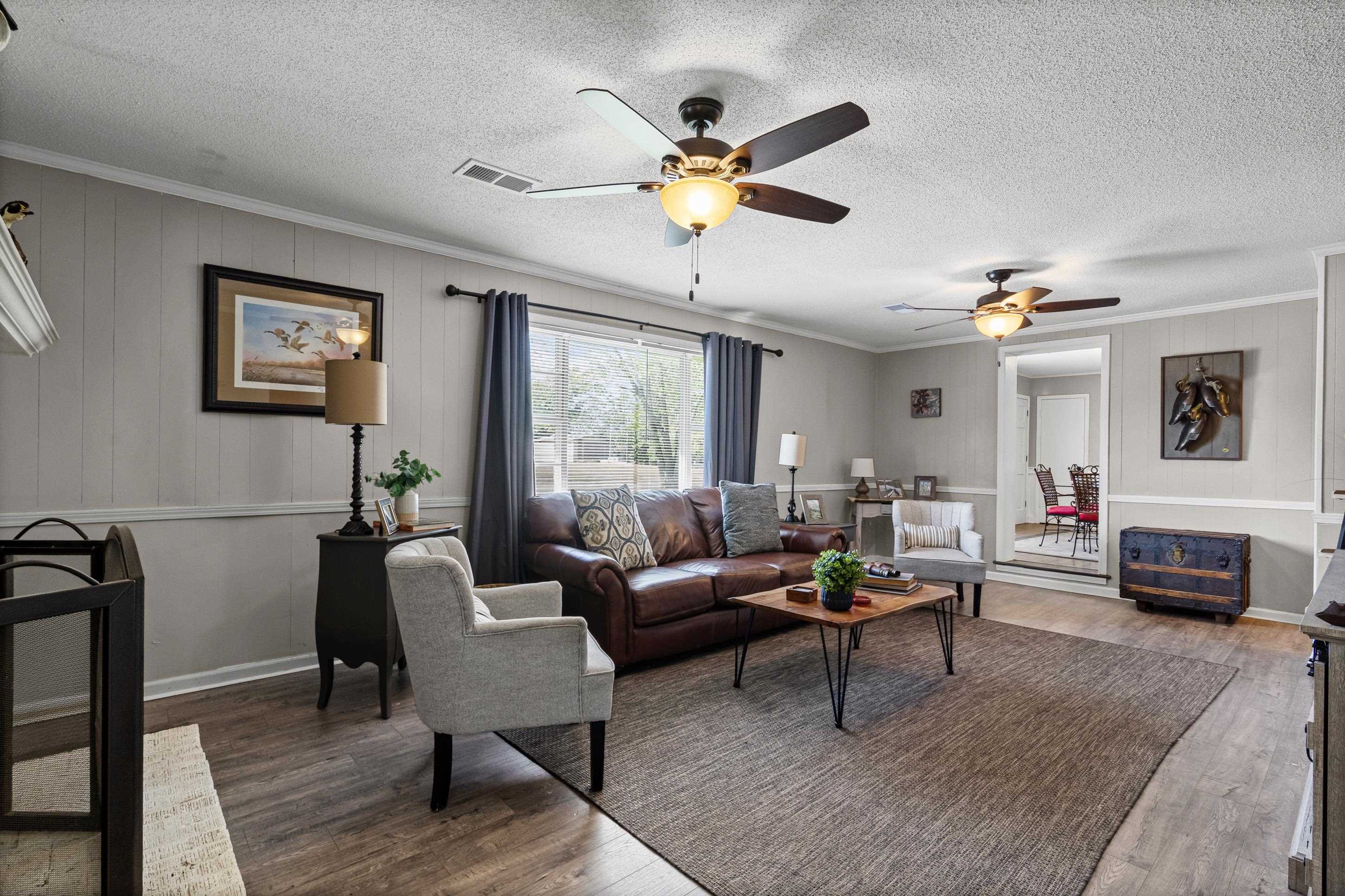 2805 Slayden Road Moscow, TN 38057 - Photo 21 of 28 Living area with crown molding, dark wood finished floors, ceiling fan, a textured ceiling, and wood walls