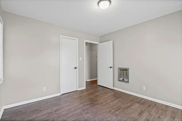 a view of an empty room with wooden floor