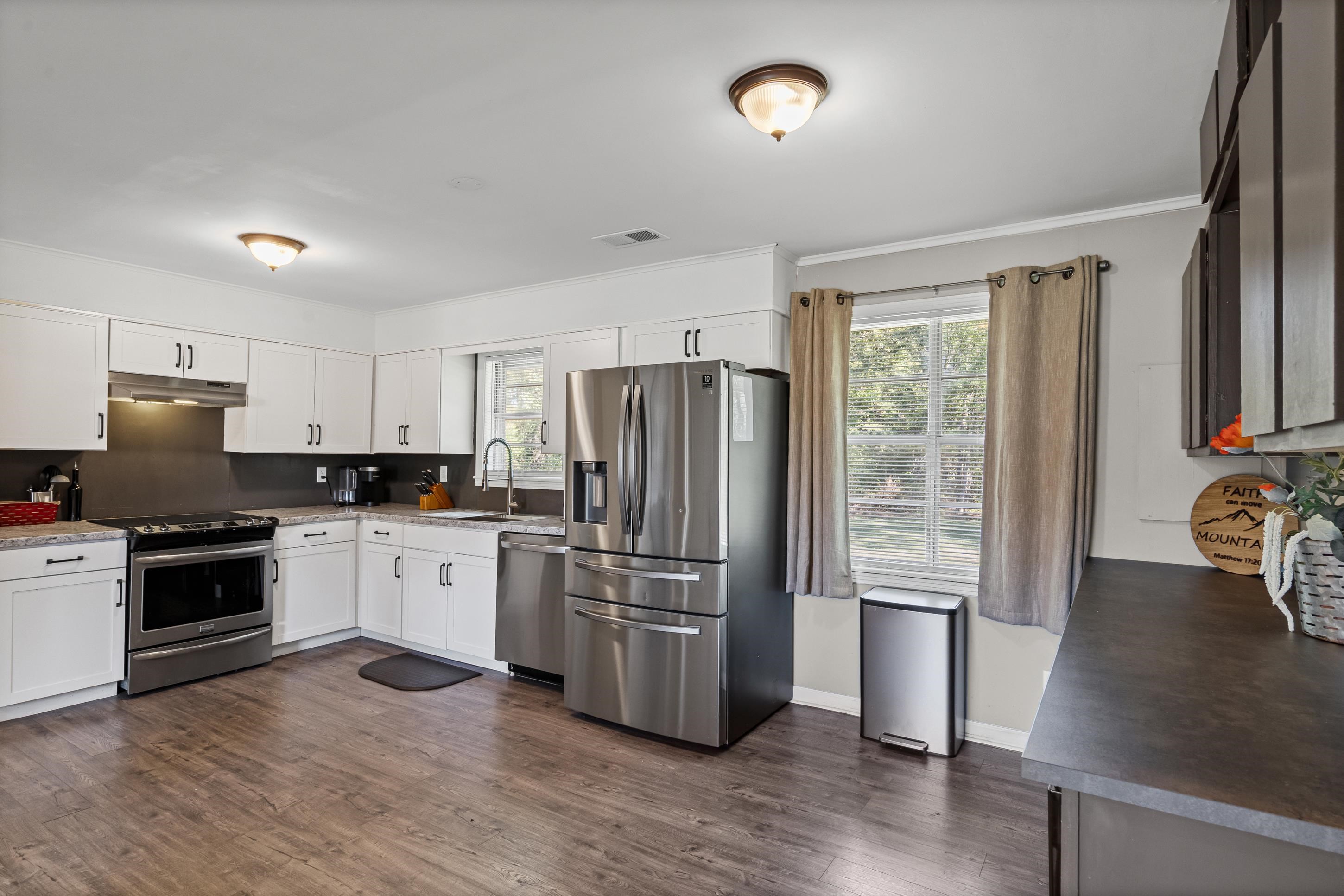2805 Slayden Road Moscow, TN 38057 - Photo 27 of 28 Kitchen with stainless steel appliances, healthy amount of natural light, decorative backsplash, dark wood-type flooring, and crown molding