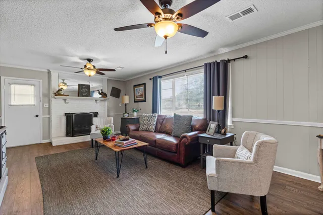 a living room with furniture a fireplace and a chandelier