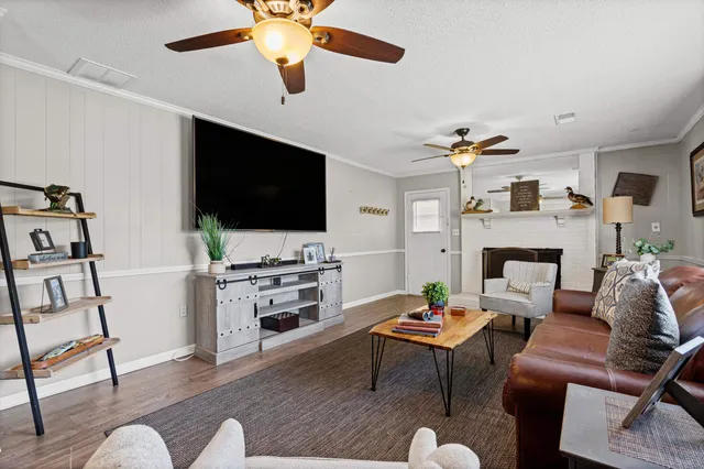 a living room with furniture a flat screen tv and a fireplace