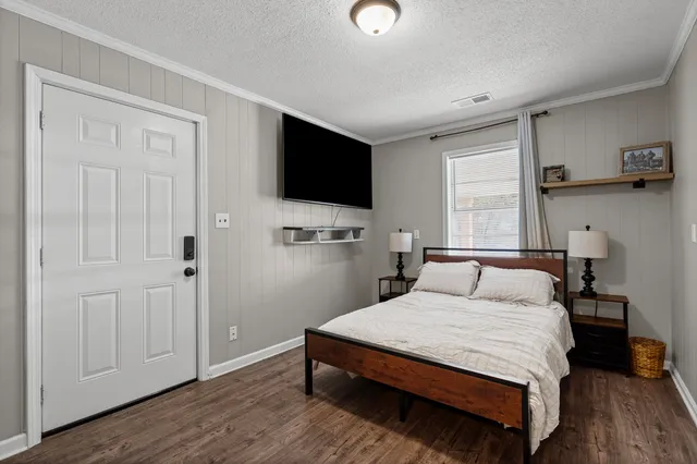 a bedroom with a bed and a flat screen tv