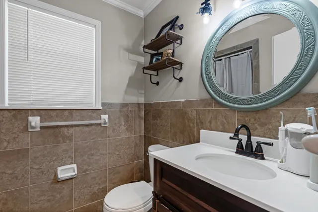a bathroom with a toilet a sink and mirror