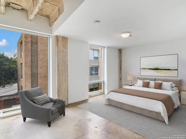 a bedroom with a bed and a large window