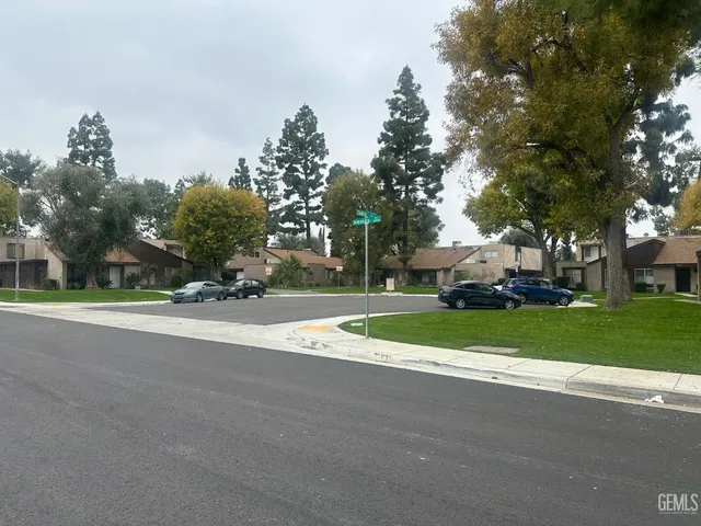 a view of road with houses and trees in the background