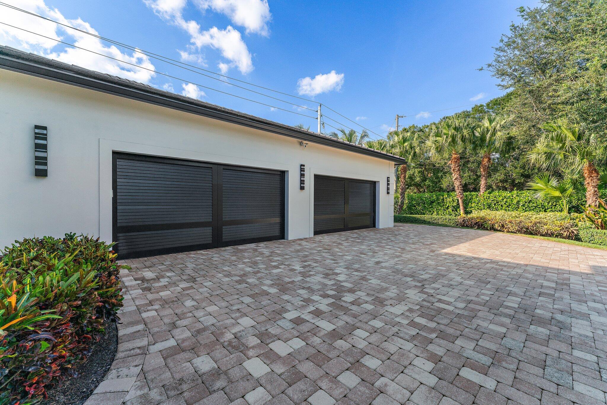 5730 Holly Lane Jupiter, FL 33458 - Photo 51 of 58 a front view of a house with a yard and garage