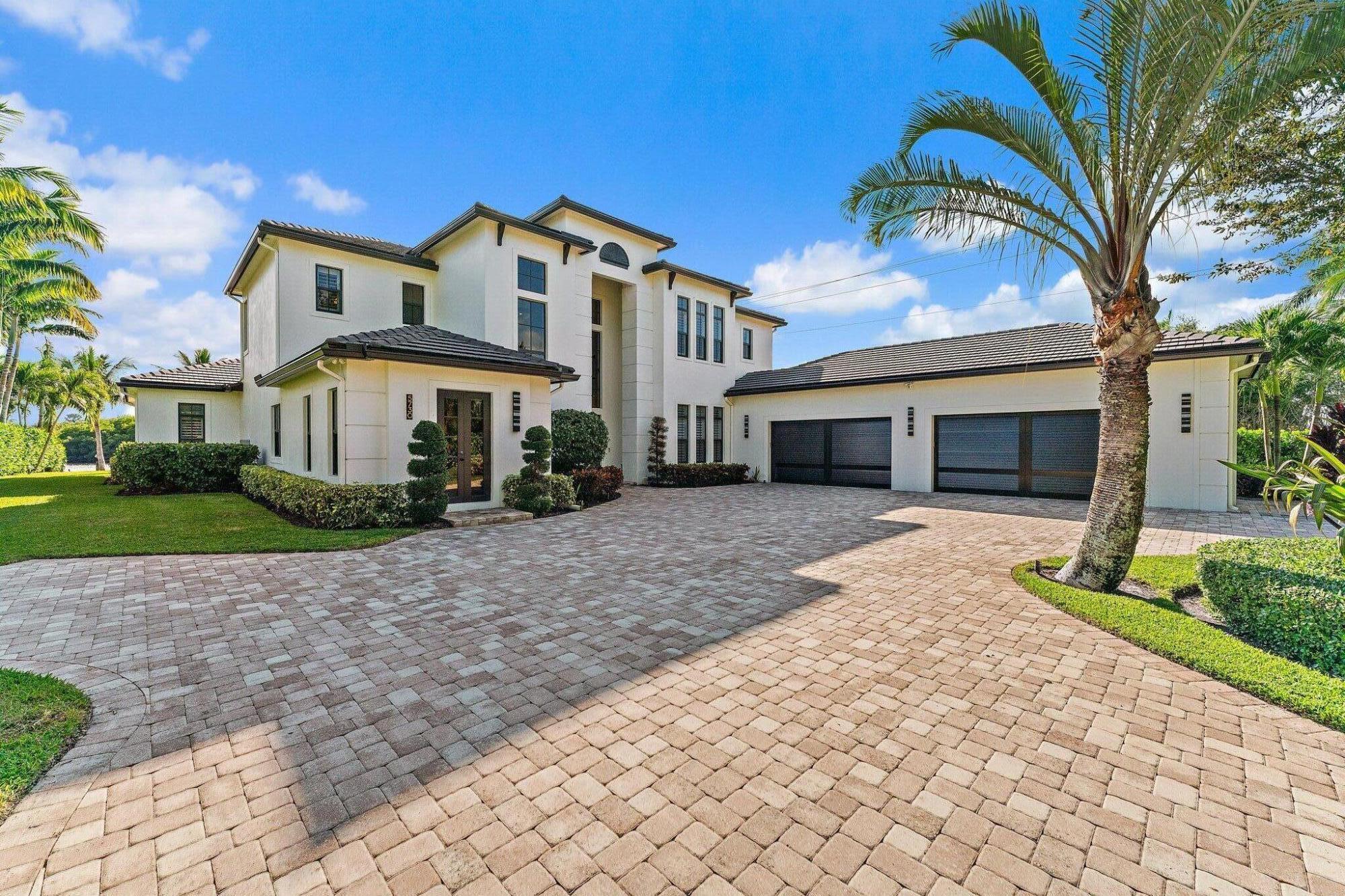 5730 Holly Lane Jupiter, FL 33458 - Photo 6 of 58 a front view of a house with a yard and a garage